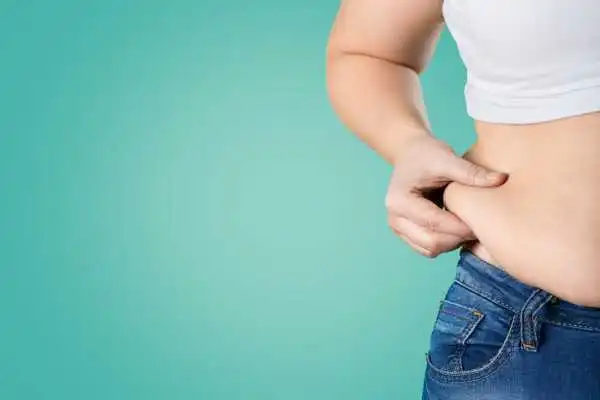 Image of woman pinching her love handles to show weight gain Romford